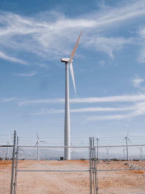 Wind Turbines on Brown Field with Fence
