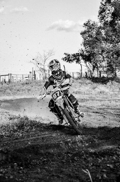 Black and White Photo of a Man Riding a Dirt Bike