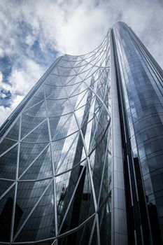 Stunning low-angle shot of a modern high-rise skyscraper in Calgary, capturing reflective glass panels and architectural design.