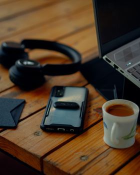 A warm, inviting workspace with a laptop, smartphone, and coffee on a wooden table.