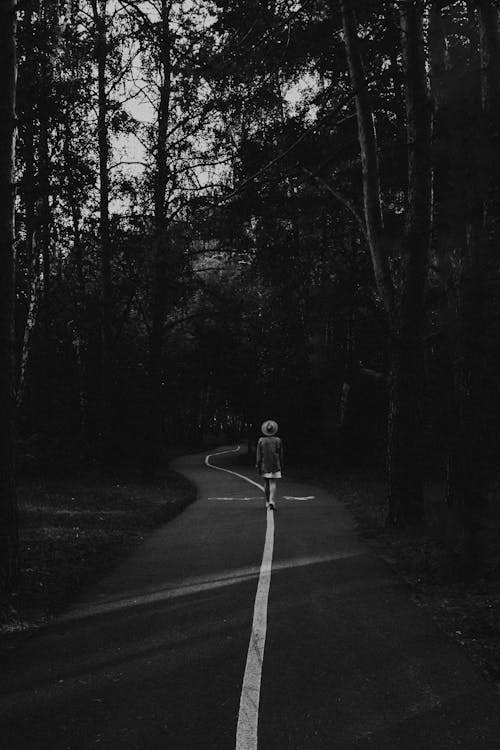 Rear view of woman walking on footpath in forest