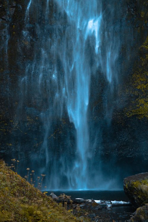 Free A stunning waterfall cascades into a serene pool surrounded by lush greenery, capturing nature's pure beauty. Stock Photo