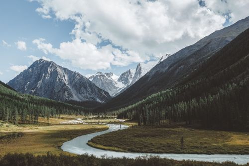 Free Explore breathtaking snowcapped mountains with a serene river valley. Perfect for nature lovers. Stock Photo