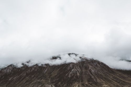 Free A scenic view of a mountain peak shrouded in clouds and mist. Perfect for nature photography. Stock Photo