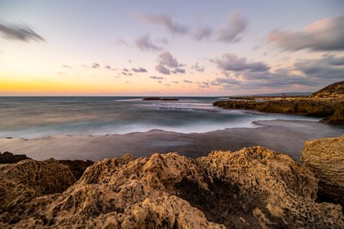Free Capture of a dramatic sunset over a rocky seascape, highlighting nature's beauty and tranquility. Stock Photo