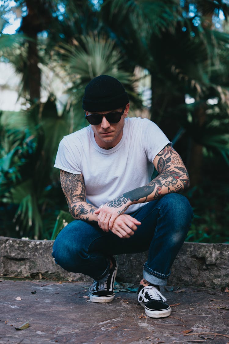 Man In Jeans And White T-shirt Crouching