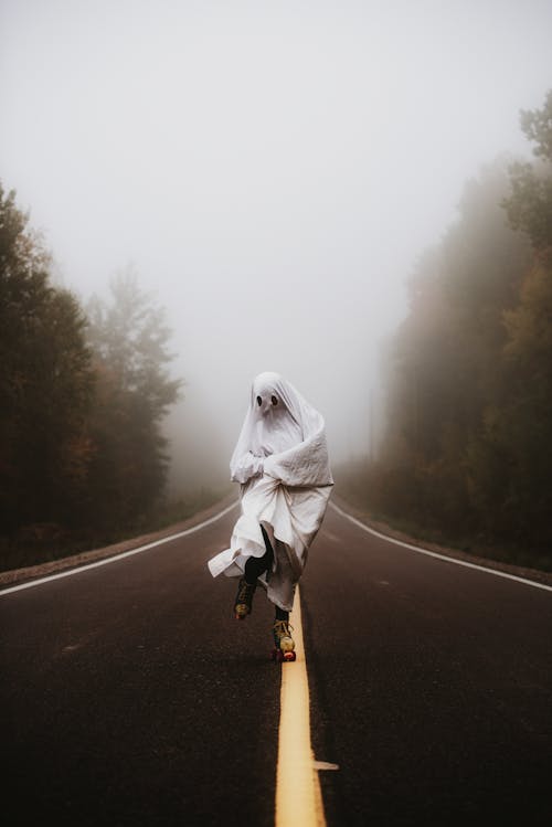 Person wearing Ghost Costume Skating on Road