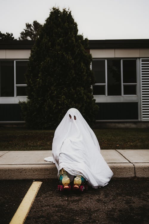 Person in ghost costume and roller skates sitting on foggy road · Free ...