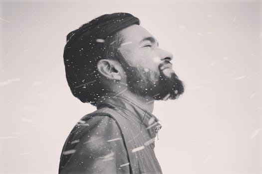 这幅灰色肖像描绘了一名男子在飘雪中平静冥想