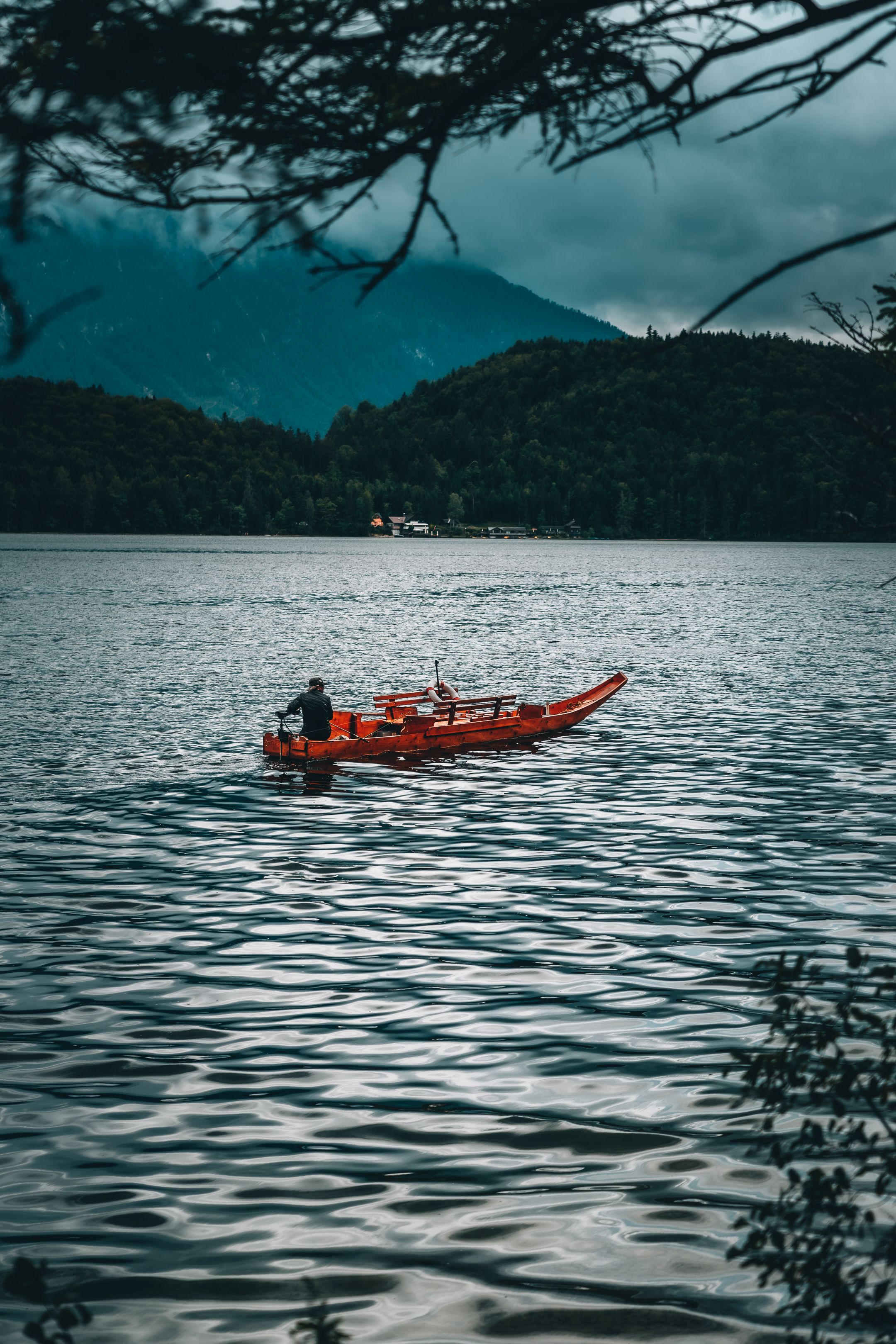 Man Riding a Red Wooden Boat on Body of Water · Free Stock Photo