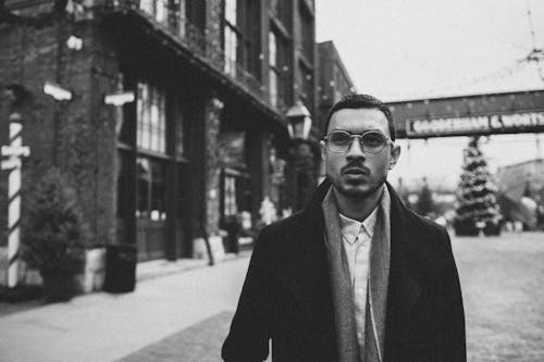 Grayscale of a Man in Coat Wearing Eyeglasses