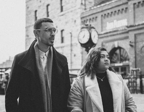 Grayscale Photo of Man and Woman Looking Away