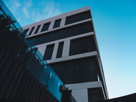 Captivating low angle view of a modern building with glass and geometric design highlighting architectural beauty.
