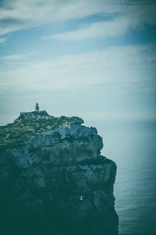 Free Majestic view of Capo Caccia cliff overlooking the serene ocean under a cloudy sky. Stock Photo