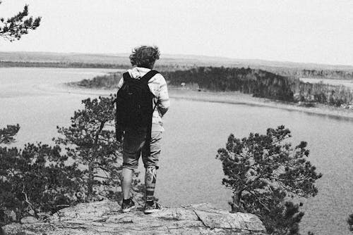 Monochrome Photo of Person standing on a Cliff 
