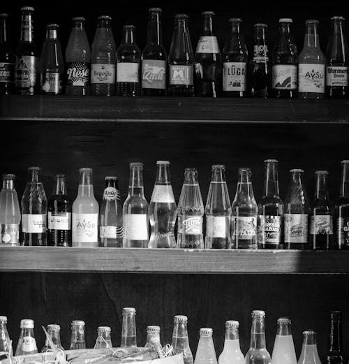Glass Bottles on Brown Wooden Shelf