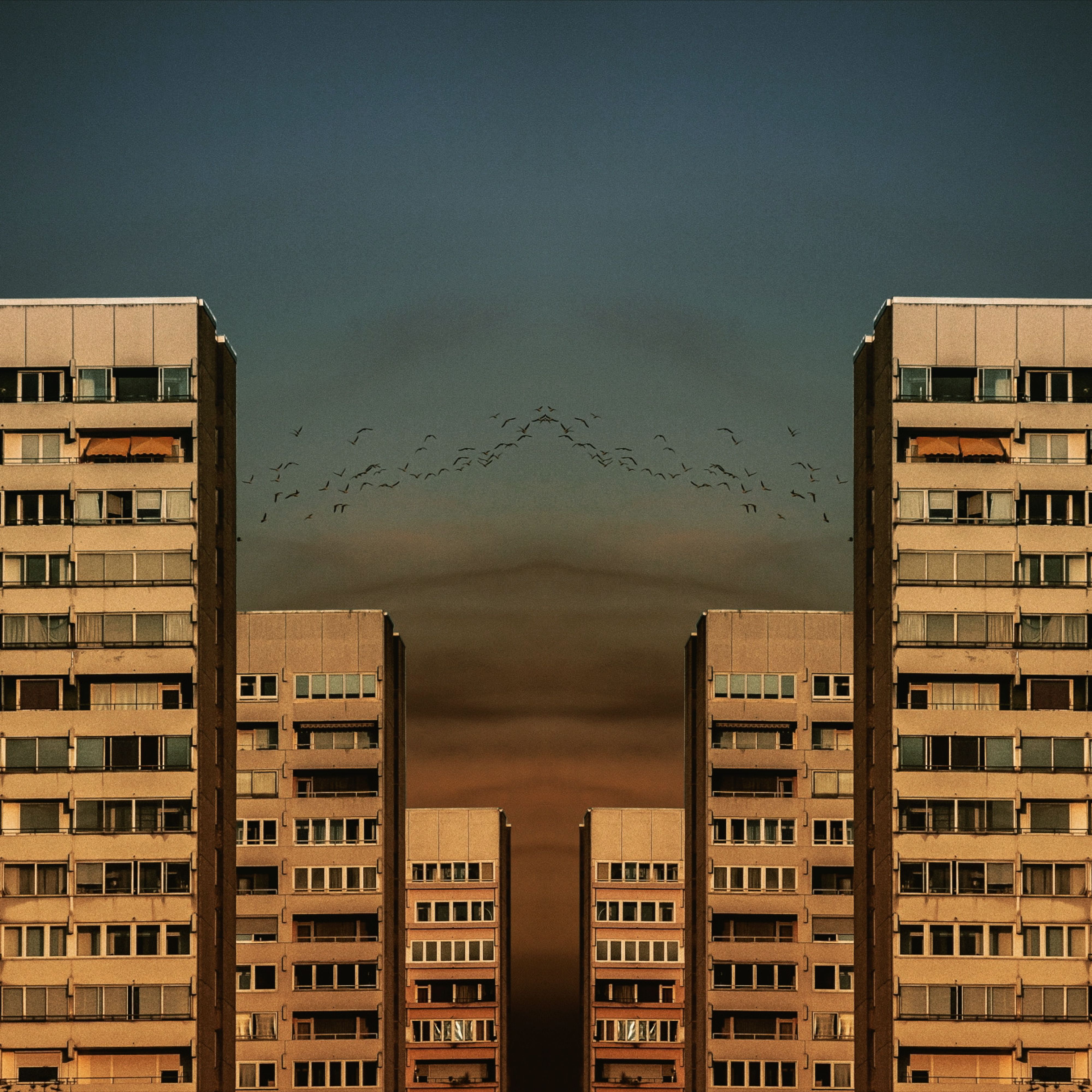 Symmetrical high-rise buildings in Augsburg, Germany, at twilight with a dramatic sky.
