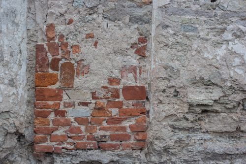 Free Close-up of a weathered brick and concrete wall texture, ideal for backgrounds. Stock Photo