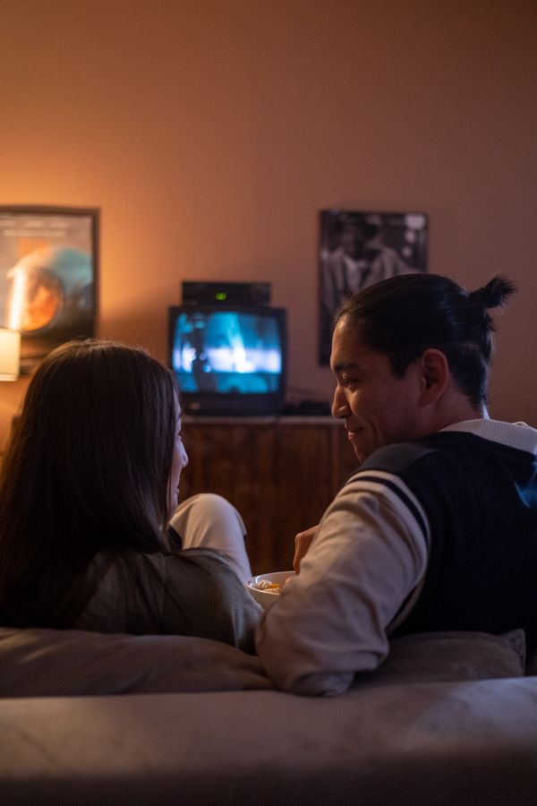 Two people watching a screen together on a couch