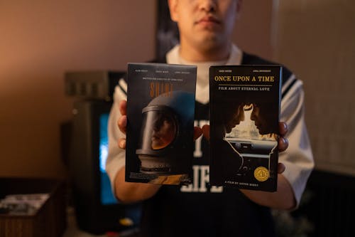 Man holding movies on videotapes