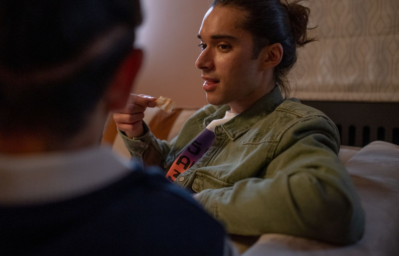 Two friends enjoying a casual conversation indoors, relaxed on a couch.
