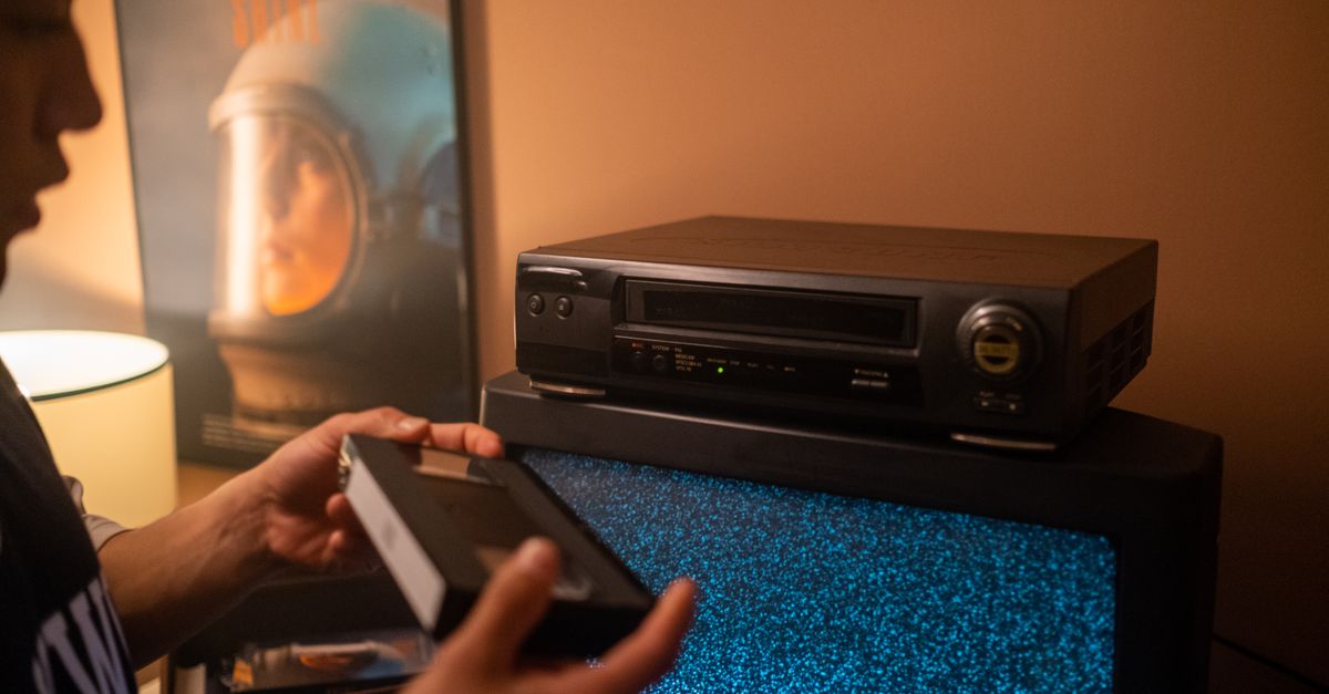 A movie poster for a fictional Y2K horror film, showing a pair of hands reaching out of a CRT monitor with the words