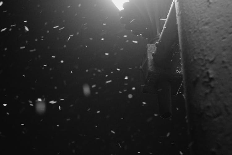 Snow Falling Around A Street Lamp