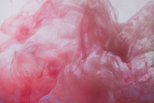 Free Vibrant pink ink swirling underwater creating abstract fluid patterns. Stock Photo