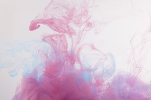 Free Vibrant and ethereal swirling patterns of pink and blue smoke against a white background. Stock Photo