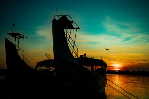 Silhouette of Boats on the Sea during Sunset