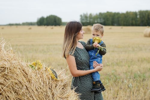 Free Charming rural scene of a mother and child enjoying a sunny day by haystacks. Stock Photo