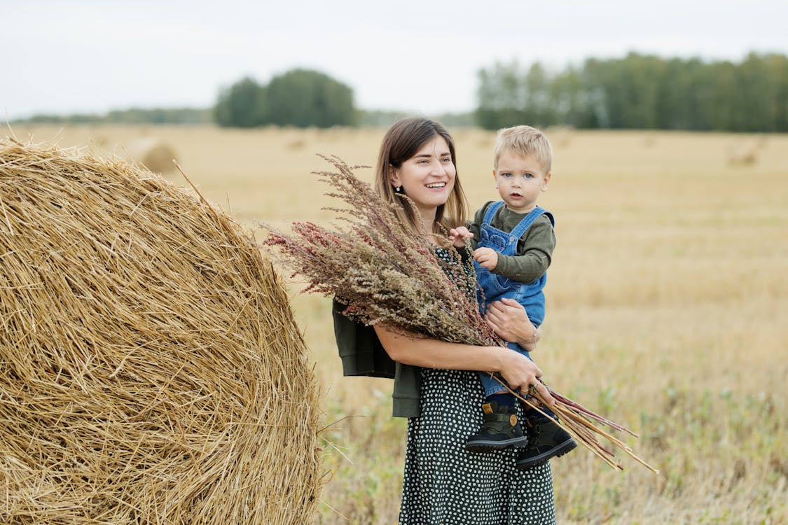 Happy Woman Holding Little Boy and Twigs