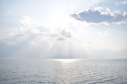 Free Peaceful seascape with sun rays piercing clouds over the ocean at Dali, Yunnan, China. Stock Photo