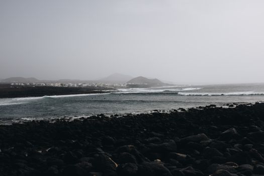 阴沉的天空下，海浪拍打着岩石海岸，景色宁静