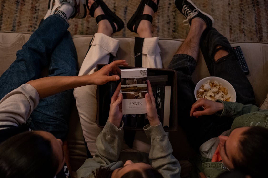 Free Directly above three friends choosing movie to watch Stock Photo