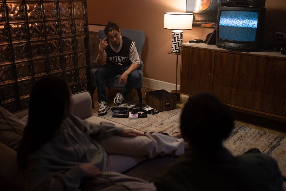 3人の友達が居心地の良い部屋でリラックスしながら、一緒に映画の夜のためにテレビを見ています。