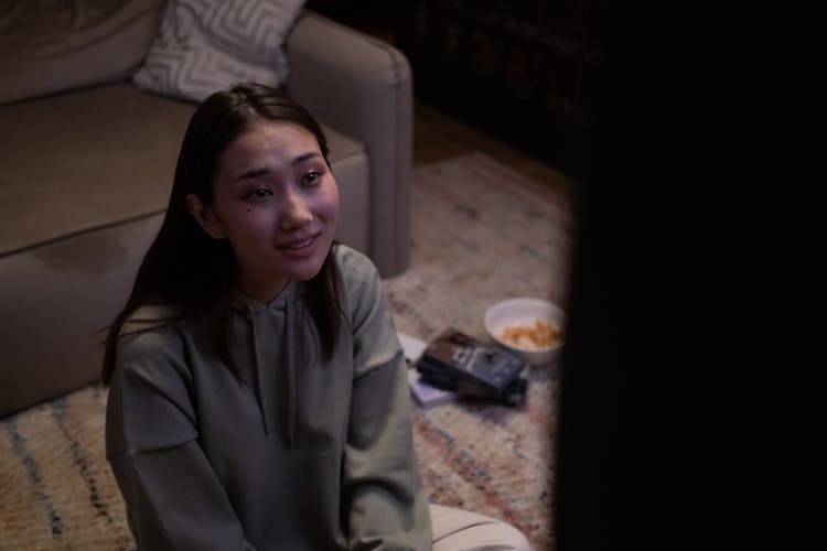 Young Girl Sitting On Floor And Watching TV