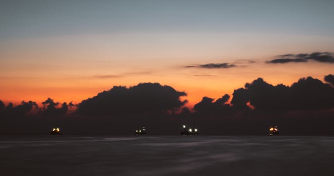 Silhouetted ships under vibrant sunset skies in Okinawa, Japan.