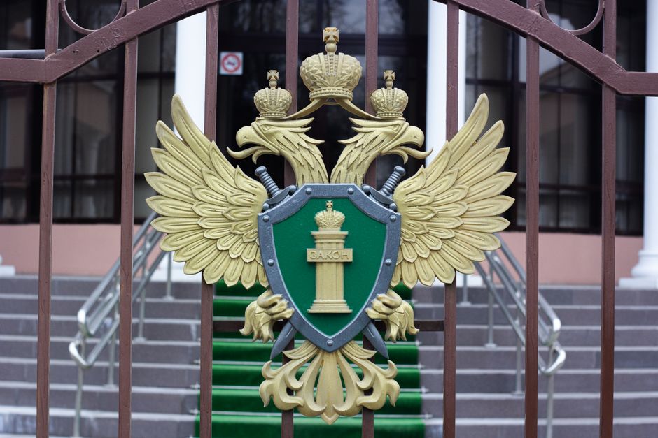 Close-up of a golden emblem with a double-headed eagle on an iron gate, signifying luxury and authority.