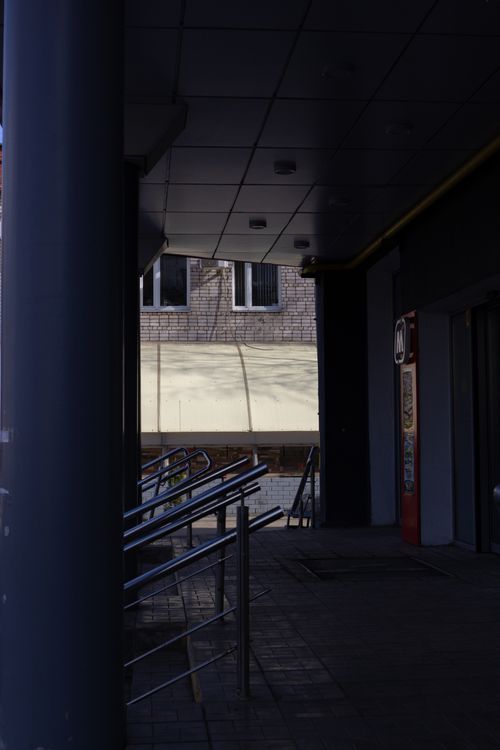 Free Dimly lit corridor with metal handrails and building facade visible outside. Stock Photo