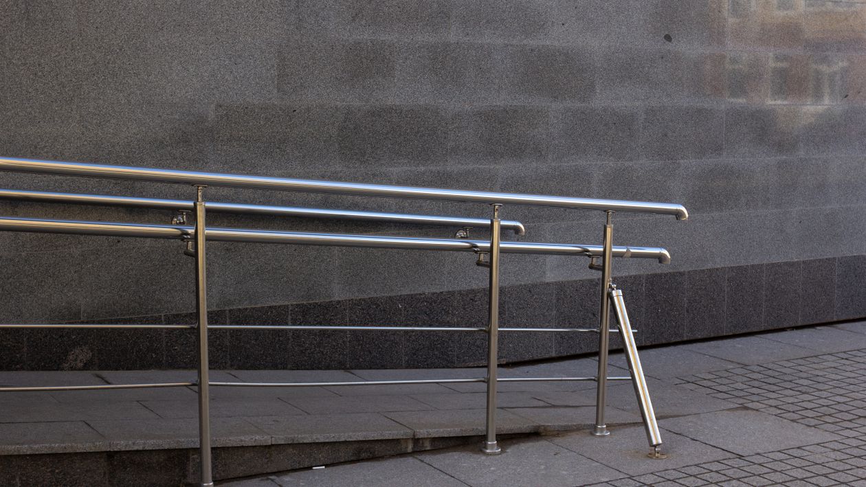 Metal handrails beside a concrete accessible ramp