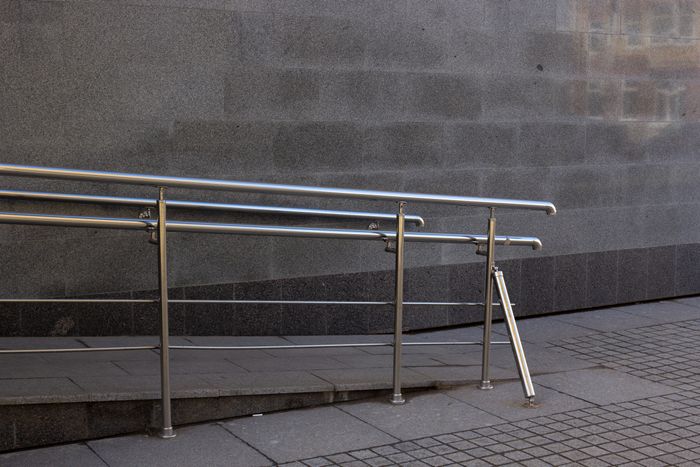 Close-up of a metal handrail and concrete ramp surface