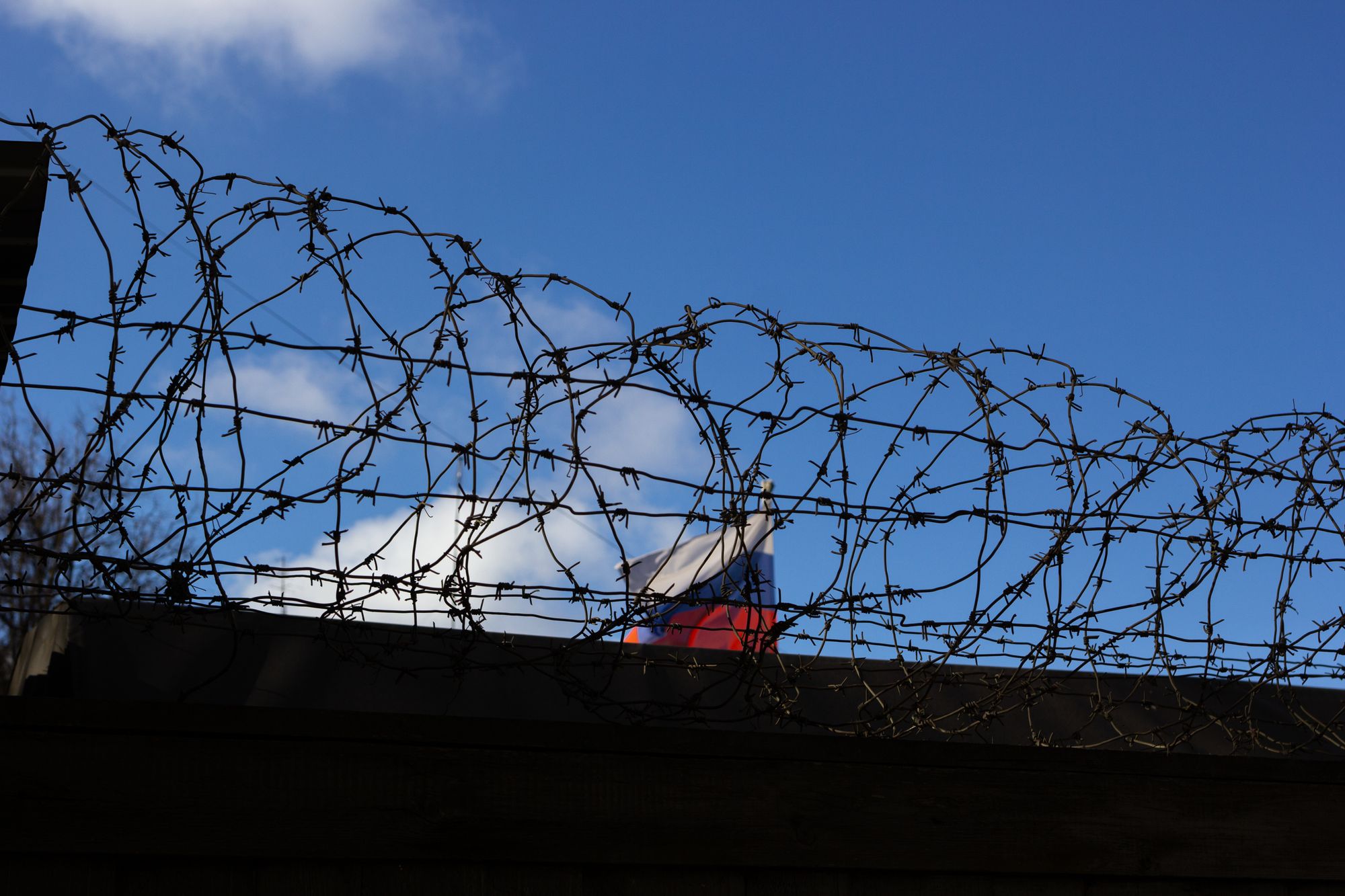 Alambre de púas sobre una barda perimetral de un centro penitenciario contra el cielo