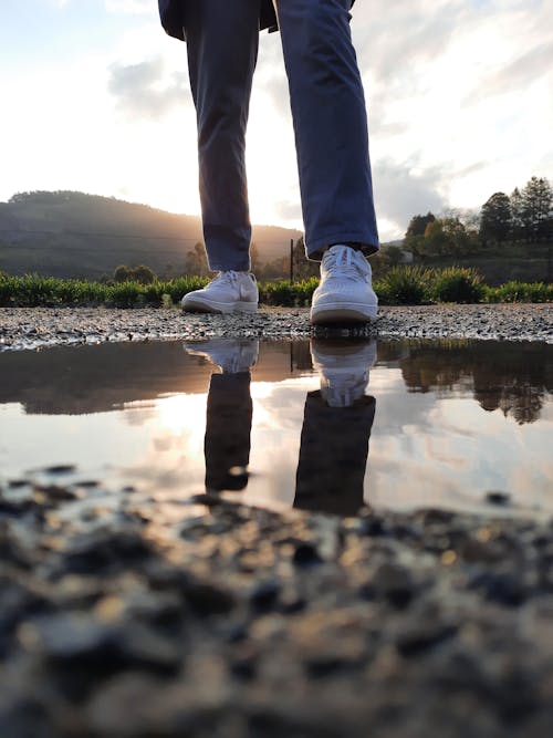 Person Standing Near the Puddle on Ground