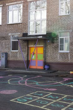 Vibrant school entrance with playful chalk art on pavement, ideal for educational themes.