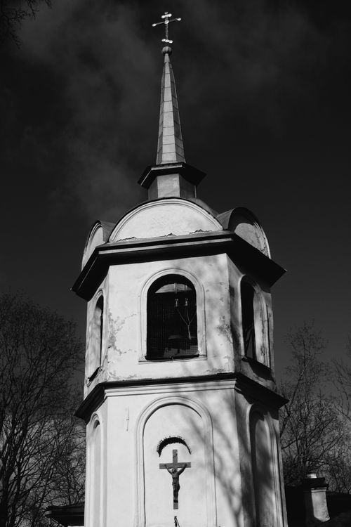 Free Low angle view of a historic church tower with a cross in black and white. Stock Photo