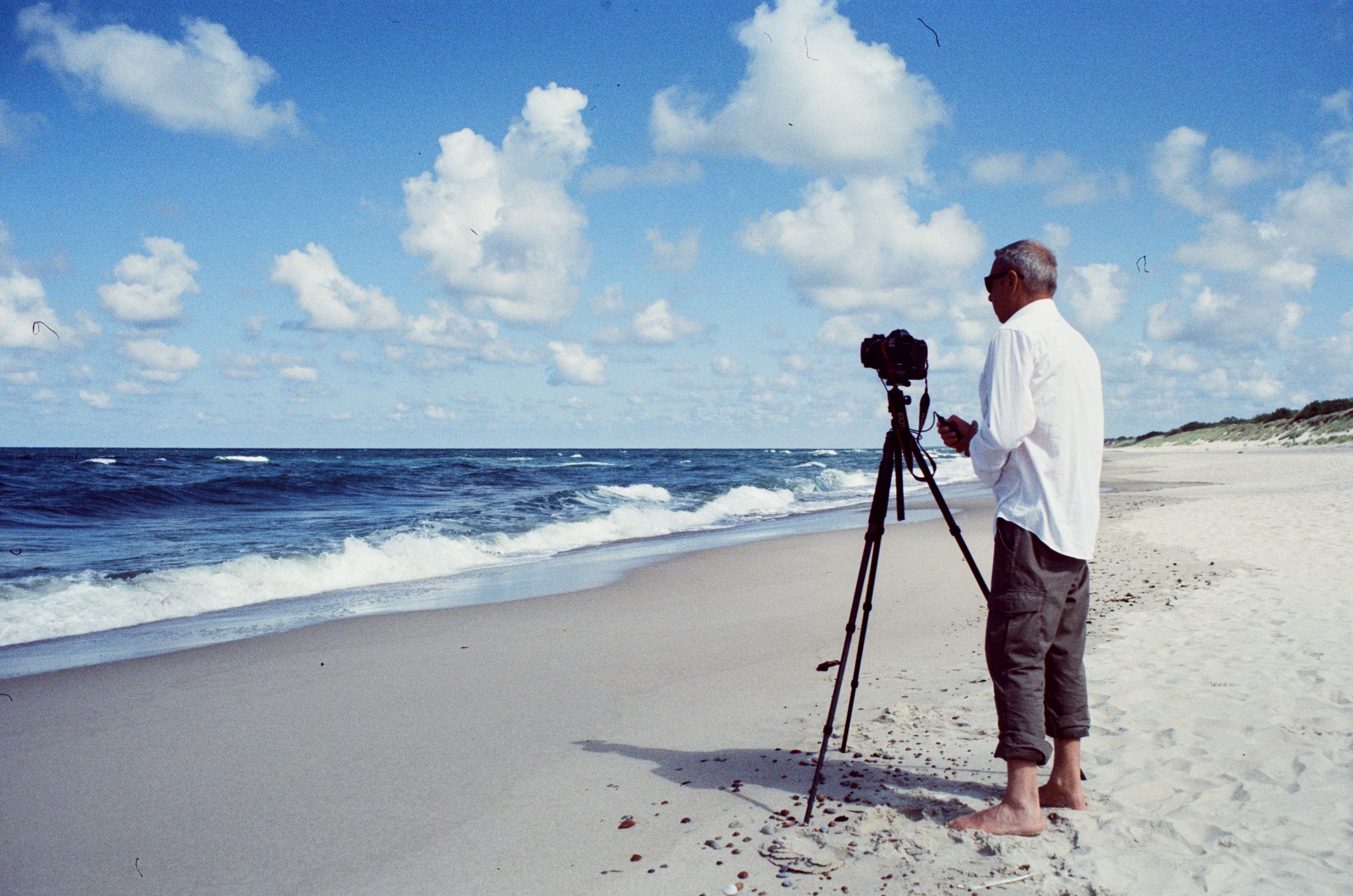 Fotograf am Strand beim Fotografieren – Digitalkamera im Einsatz