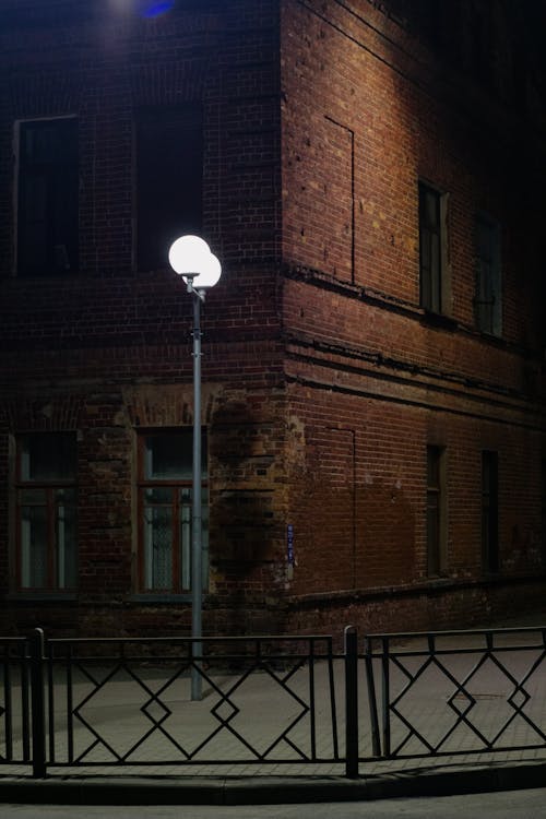 A Black Metal Fence Near Brown Concrete Building during Night