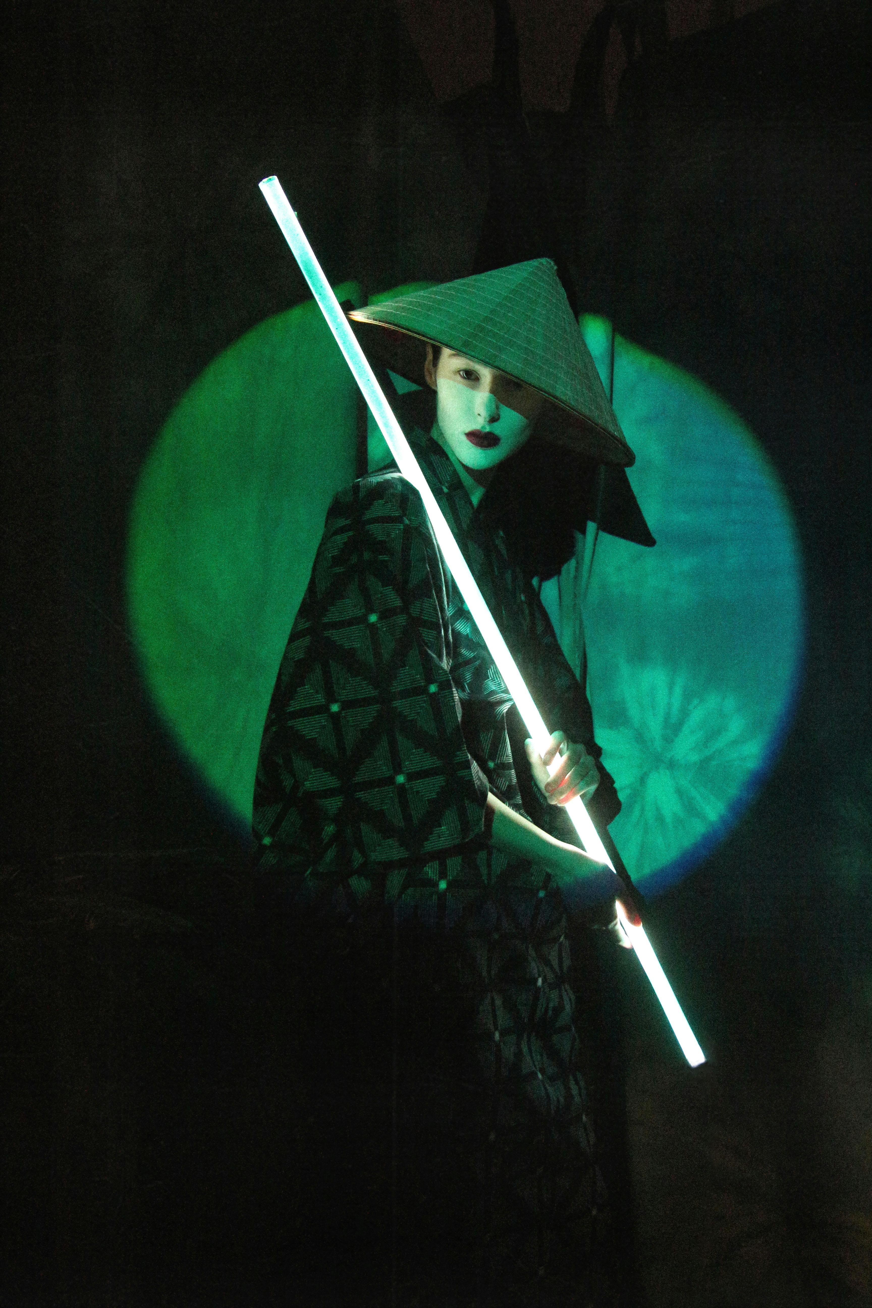 A captivating studio portrait of a woman in traditional attire holding a neon light.