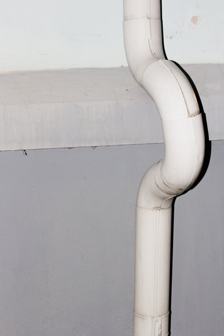 White Downspout On Concrete Wall